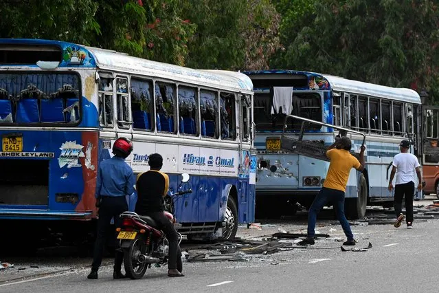 Anti-government protesters destroy a damage bus in Colombo on May 9, 2022. At least three people were killed and more than 150 wounded on May 9 in a wave of violence between government supporters and demonstrators demanding President Gotabaya Rajapaksa's resignation. (Photo by Ishara S. Kodikara/AFP Photo)