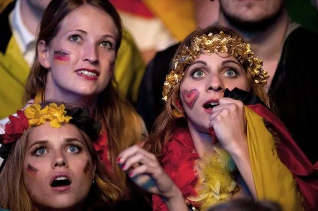 German soccer fans watch the Brazil World Cup final 2014 being played in Rio de Janeiro, Brazil, between Germany and Argentina at a public viewing area called “Fan Mile” in Berlin, Sunday, July 13, 2014. (Photo by Steffi Loos/AP Photo)