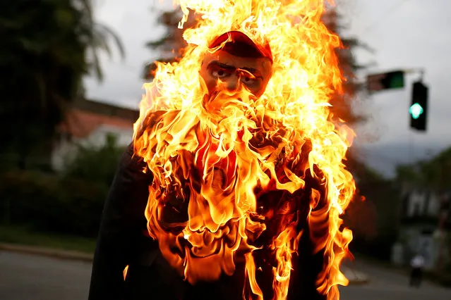 An effigy depicting Venezuela's President Nicolas Maduro is set alight during the traditional burning of Judas as part of Holy Week celebrations, at a street in Caracas, Venezuela April 16, 2017. (Photo by Marco Bello/Reuters)