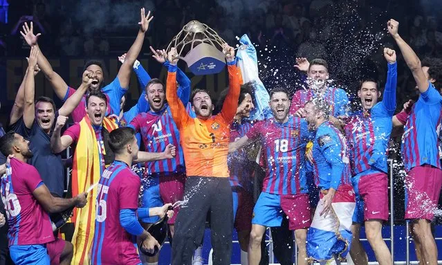 Barcelona goalkeeper Gonzalo Perez de Vargas holds the trophy as team Barca celebrates after winning the Final Four Champions League handball final match between Lomza Vive Kielce and FC Barcelona in Cologne, Germany, Sunday, June 19, 2022. (Photo by Martin Meissner/AP Photo)