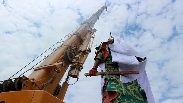 A crane is used to cover the statue of Guan Yu, a Chinese deity,  with a cloth in Tuban, about 100 km (60 miles) west of Indonesia's second-biggest city of Surabaya, East Java, Indonesia August 6, 2017 in this photo taken by Antara Foto. (Photo by Aguk Sudarmojo/Reuters/Antara Foto)