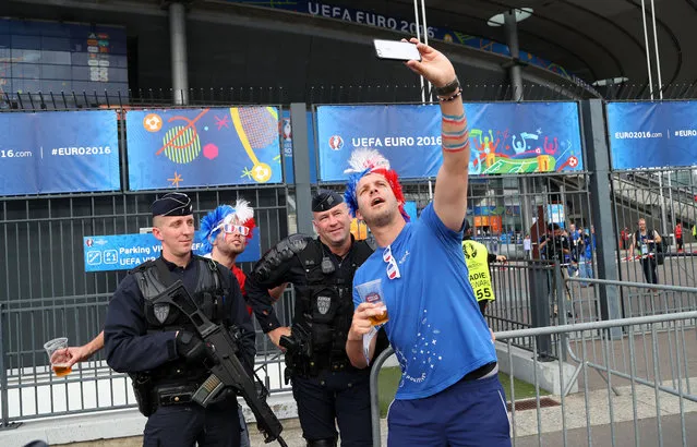 France supporters take a selfie with French police officers outside the stadium before the Euro 2016 Group A soccer match between France and Romania, at the Stade de France, in Saint-Denis, north of Paris, Friday, June 10, 2016. (Photo by Thibault Camus/AP Photo)