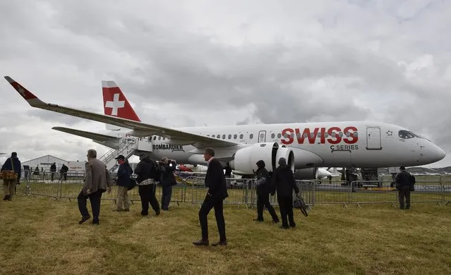 Plane enthusiasts look at a Swiss C-Series plane on display at The Farnborough International Airshow in Farnborough, Britain, 12 July 2016. (Photo by Hannah Mckay/EPA)