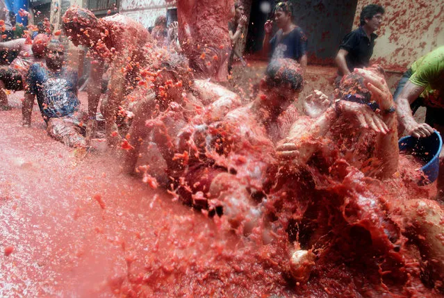 Revellers play in tomato pulp during the annual Tomatina festival in Bunol near Valencia, Spain on August 30, 2017. (Photo by Heino Kalis/Reuters)