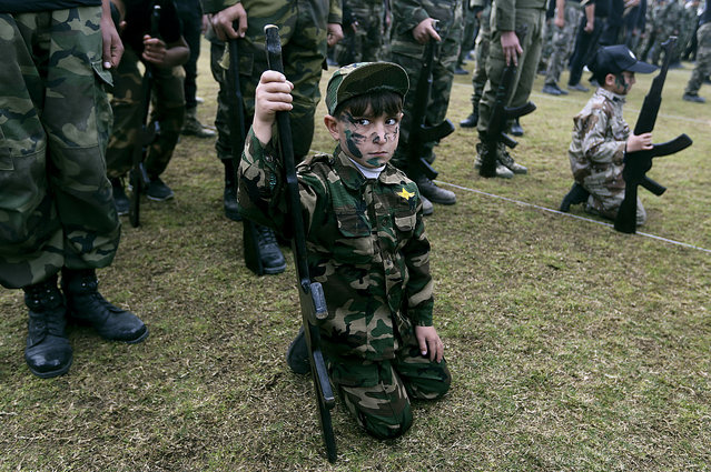 Young Palestinian students hold mock rifles while participating in a graduation ceremony from a Hamas-run military training program in Gaza City, Tuesday, January 14, 2014. Thousands of male Palestinian students learned how to climb down buildings on ropes, run through obstacle courses and crawl under barbed wire in weekly one-hour mandatory sessions. (Photo by Hatem Moussa/AP Photo)