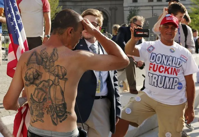 A reporter speaks with a demonstrator displaying his tattoos near the Republican National Convention in Cleveland, Ohio, U.S. July 18, 2016. (Photo by Lucas Jackson/Reuters)