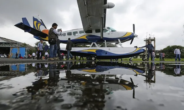 A man take a picture of a Cessna 208 Caravan 1 seaplane before it departs off from Juhu Aerodrome in Mumbai August 25, 2014. According to a media release, Mumbai's first leg of the commercial seaplane service connects the city to Pawna Dam, a water body near Lonavala, a popular tourist destination. (Photo by Shailesh Andrade/Reuters)