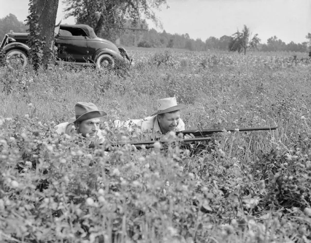In this July 28, 1942 file photo, two members of the Maryland Minute Men, a civilian defense organization, hold their rifles as they lie low in a southern Maryland hay field during a search for traces of parachutists during World War II. State and federal agencies joined in hunt in Crownsville, Md. (Photo by AP Photo)