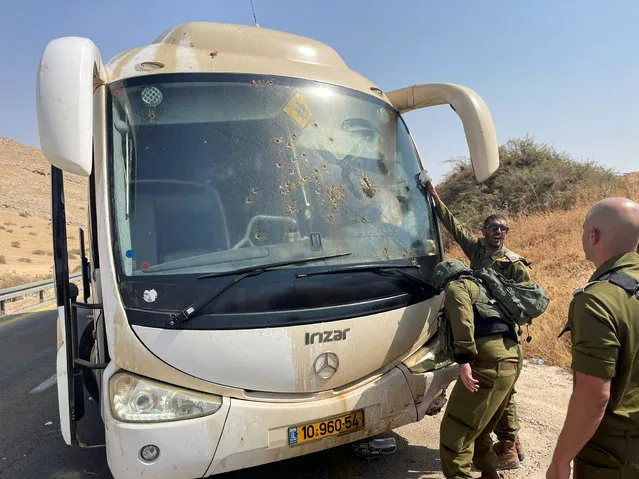 Israeli soldiers check damage in a bus, at the scene of a shooting attack in the Jordan Valley, in the Israeli-occupied West Bank on September 4, 2022. (Photo by Adel Abu Nemeh/Reuters)
