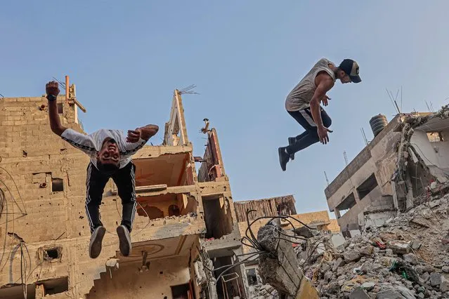 Palestinian youths practise parkour amid the rubble of buildings destroyed by Israeli airstrikes in the latest round of fighting between Israel and Palestinian militants, in Rafah in the southern Gaza Strip, on August 20, 2022. (Photo by Said Khatib/AFP Photo)