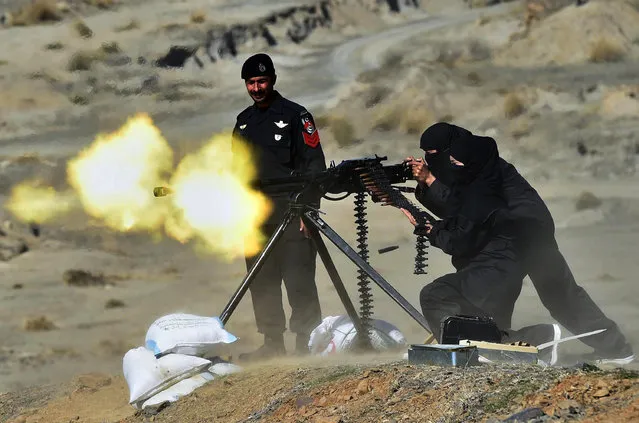 A Pakistani policewoman fires a heavy machine gun during a special elite police training course at a police training centre in Nowshera, a district in the Khyber Pakhtunkhwa Province on February 11, 2015. Dozens of male and female police took part in a commando training course, introduced by the local police as an additional skill for the police to be deployed to confront terrorism and extremism which is routinely on the rise in this South Asian nuclear-armed country. (Photo by A. Majeed/AFP Photo)