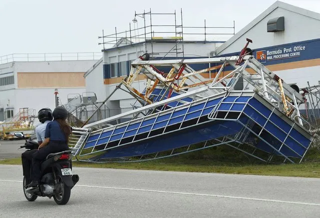 A motorcyclist rides past a structure turned on its side in the aftermath of Hurricane Fiona, in St. George, Bermuda, Friday, September 23, 2022. (Photo by Akil Simmons/AP Photo)