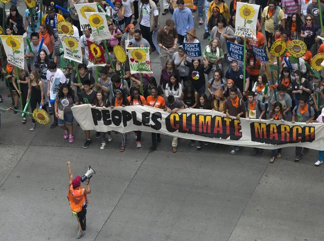 Activists hold a banner as they lead a march of tens of thousands down 6th Avenue during the People's Climate March through Midtown, New York September 21, 2014. (Photo by Adrees Latif/Reuters)