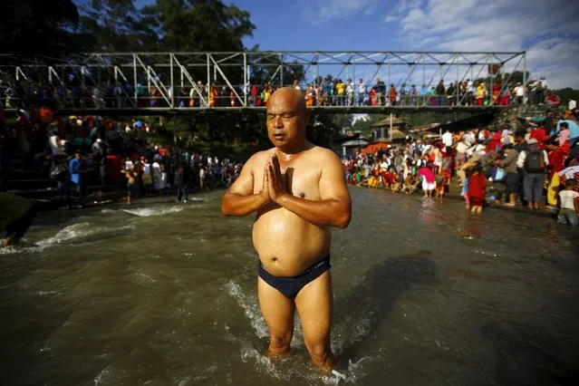 A Hindu devotee performs a ritual on Bagmati River during Kuse Aunse (Father's Day) at Gokarna Temple in Kathmandu, Nepal September 13, 2015. (Photo by Navesh Chitrakar/Reuters)