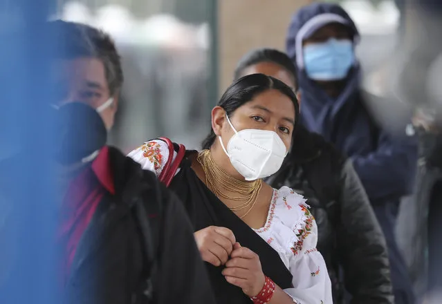 Passengers wearing protective face masks as a precaution against the spread of the new coronavirus, wait in a bus line, in Quito, Ecuador, Wednesday, June 3, 2020. After 80 days of an almost complete shutdown, the capital city lowers its warning alert from red to yellow allowing for the freer movement of people and the opening of many businesses. (Photo by Dolores Ochoa/AP Photo)