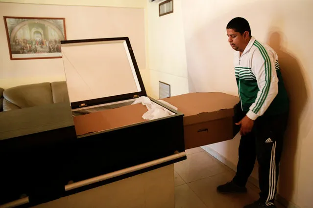 A man puts a cardboard coffin inside a crate at a mortuary in Valencia, in the state of Carabobo, Venezuela August 25, 2016. (Photo by Marco Bello/Reuters)