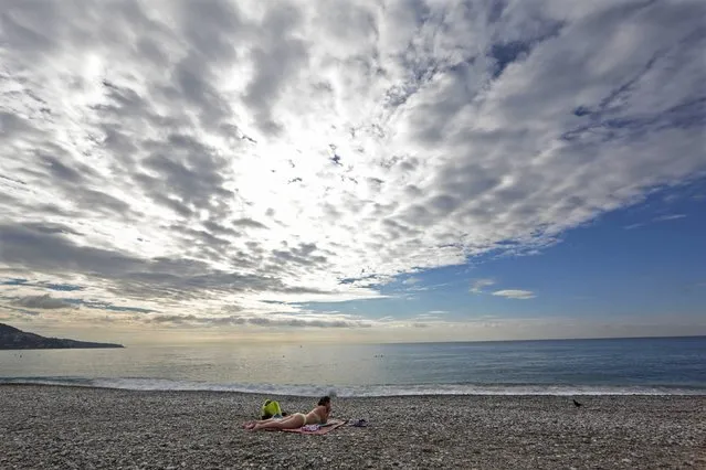 A woman sunbathes as she takes advantage of warm autumn weather temperatures on the beach in Nice October 1, 2014. (Photo by Eric Gaillard/Reuters)