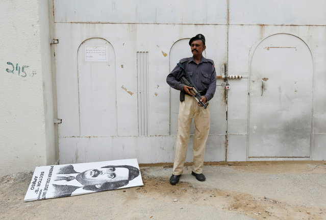 A policeman stands guard at an entrance gate with wax-sealed padlock, beside a poster depicting Altaf Hussain, leader of Muttahida Qaumi Movement (MQM) political party, after paramilitary forces sealed the headquarters in Karachi, Pakistan, August 23, 2016. (Photo by Akhtar Soomro/Reuters)