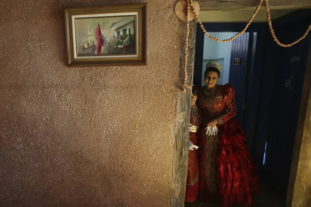 In this November 12, 2017 photo, Luana Borges, playing the part of the Portuguese empress, right, and her daughter Luana Silva prepare to join the Azorean Culture Festival which celebrates the culture of the Azores, the Portuguese island chain in the mid-Atlantic, in Enseada de Brito, in Brazil's Santa Catarina southern state. The communities of Santa Catarina have preserved some artisanal methods of lace making since lost in the Azores themselves. (Photo by Eraldo Peres/AP Photo)