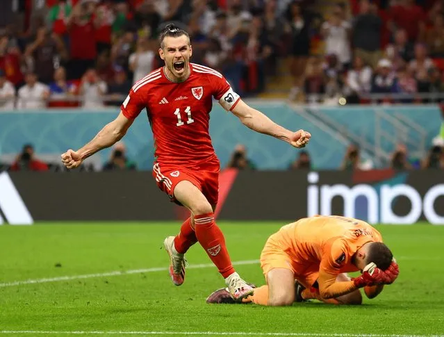 Gareth Bale of Wales celebrates with teammates after scoring their team's first goal via a penalty past Matt Turner of United States during the FIFA World Cup Qatar 2022 Group B match between USA and Wales at Ahmad Bin Ali Stadium on November 21, 2022 in Doha, Qatar. (Photo by Hannah Mckay/Reuters)