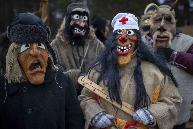 Revellers wearing traditional carnival masks take part in Shrovetide celebrations, in Rumsiskes village, some 89 kilometres (56 miles) north of Vilnius, Lithuania, Saturday, February 10, 2024. A strange scenario took place in this central Lithuania village this weekend as chanting devils, goats, witches and others filled the streets to chase winter away. Shrovetide is a traditional Lithuanian holiday marking the end of winter. (Photo by Mindaugas Kulbis/AP Photo)