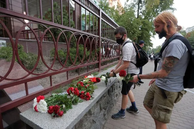 People place flowers in memory of a protester who died on August 10 in Minsk during a protest against Belarusian presidential election results, outside the Belarusian embassy in Kyiv, Ukraine on August 11, 2020. (Photo by Valentyn Ogirenko/Reuters)