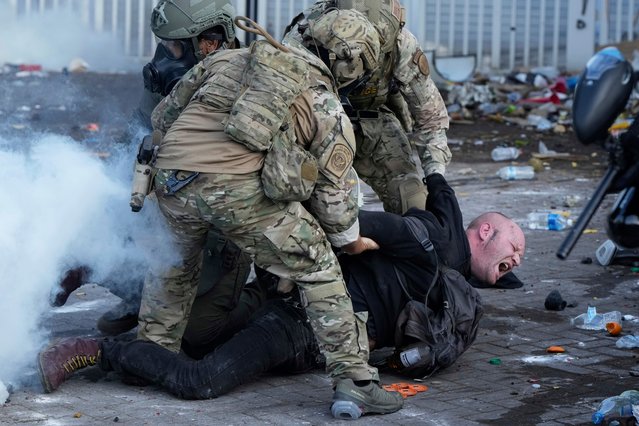 U.S. Customs and Border Protection agents detain a man outside the U.S. Immigration and Customs building during a protest Saturday, June 14, 2025, in Portland, Ore. (Photo by Jenny Kane/AP Photo)
