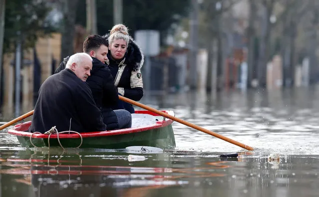 Residents on a small boat leave home in a flooded street of Villeneuve-Saint-Georges, near Paris, France, January 26, 2018. The Paris region has been deeply affected by the floods that hit the country over the past week, but in Paris, it was business as usual. (Photo by Christian Hartmann/Reuters)