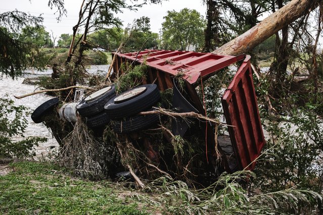 A large truck is impaled onto a tree after flash flooding on the bank Guadalupe River on July 5, 2025 in Center Point, Texas. Heavy rainfall caused flooding along the Guadalupe River in central Texas with multiple fatalities reported. (Photo by Jim Vondruska/Getty Images)