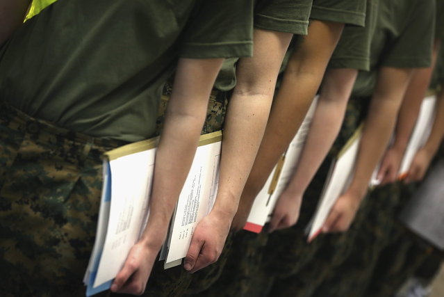 Female Marine recruits stand in line while they wait for a dental examination on their first full day of boot camp on February 26, 2013 at MCRD Parris Island, South Carolina. Female enlisted Marines have gone through recruit training at the base since 1949. About 11 percent of female recruits who arrive at the boot camp fail to complete the training, which can be physically and mentally demanding. On January 24, 2013 Secretary of Defense Leon Panetta rescinded an order, which had been in place since 1994, that restricted women from being attached to ground combat units. (Photo by Scott Olson/AFP Photo)