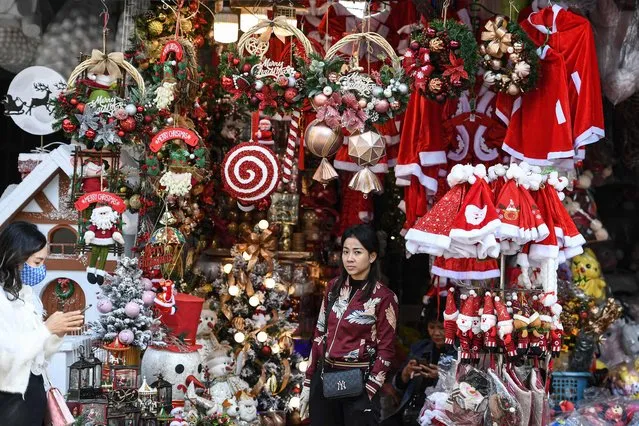 A shopkeeper waits for customers at a shop selling Christmas decorations in downtown Hanoi on December 13, 2022. (Photo by Nhac Nguyen/AFP Photo)