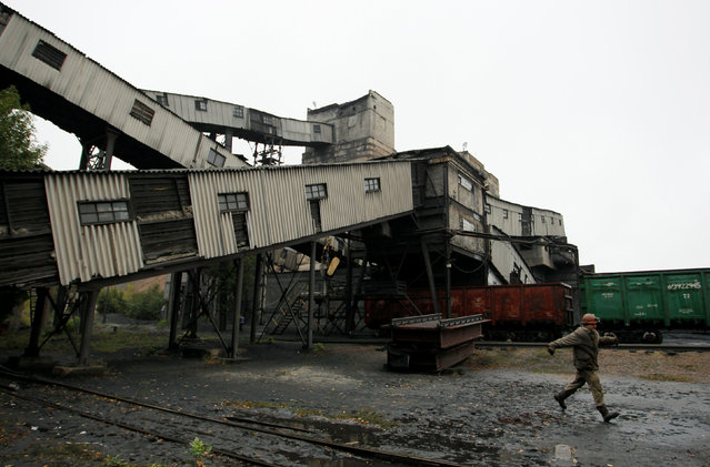 An employee walks at the “Kholodnaya Balka” coal mine, owned by MakeevUgol company in Makeyevka (Makiivka), a town controlled by forces of the self-proclaimed Donetsk People's Republic, in Donetsk region, Ukraine, September 26, 2016. (Photo by Alexander Ermochenko/Reuters)
