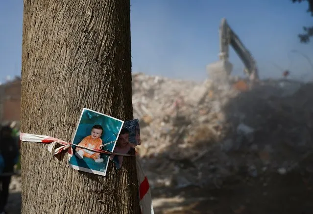 Photographs of children are fixed to a tree near rubble, in the aftermath of a deadly earthquake in Kahramanmaras, Turkey on February 14, 2023. (Photo by Suhaib Salem/Reuters)