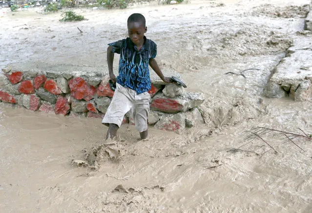 A Haitian boy walks along a flooded street in Fonds Parisiens, western Haiti, 04 October 2016. Hurricane Matthew made landfall on 04 October in western Haiti, causing mudslides and flooding, while two children were reported killed in neighboring Dominican Republic when their family's house collapsed in the heavy rains from the storm. (Photo by Orlando Barria/EPA)