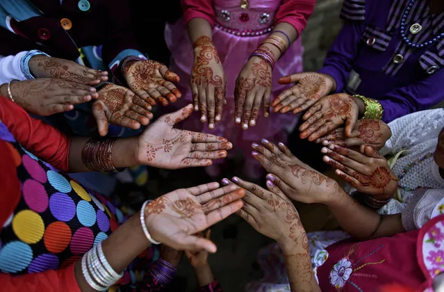 Pakistani Christian girls, display their hands decorated with Bangles and painted with Henna paste as they celebrate Easter holiday following a mass at in a Christian neighborhood in Islamabad, Pakistan, Sunday, March 31, 2013. Pakistan's Christians, are celebrating Easter along with other Christian nations. (Photo by Muhammed Muheisen/AP Photo)
