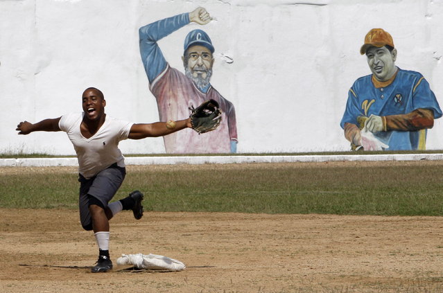 A prisoner plays baseball at the Combinado del Este prison, where a mural of Cuban leader Fidel Castro and Venezuela's late President Hugo Chavez cover a wall, during a media tour of the prison in Havana, Cuba, Tuesday, April 9, 2013.  Cuban authorities led foreign journalists through the maximum security prison, the largest in the Caribbean country that houses 3,000 prisoners. Cuba says they have 200 prisons across the country, including five that are maximum security. (Photo by Franklin Reyes/AP Photo)