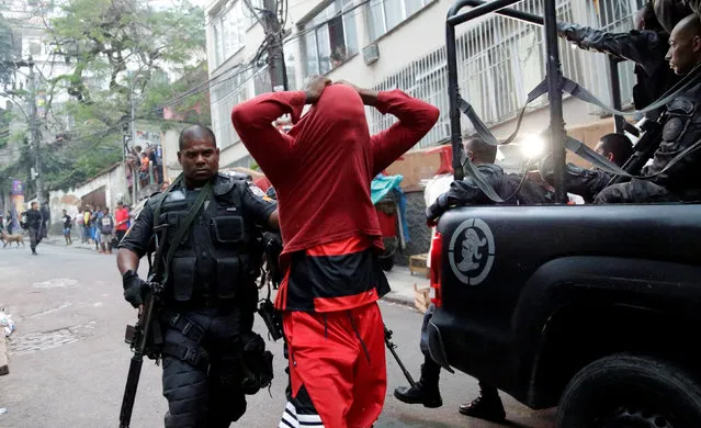 A police officer arrests a suspected drug dealer after a shootout during a police operation at Pavao-Pavaozinho slum in Rio de Janeiro, Brazil, October 10, 2016. (Photo by Ricardo Moraes/Reuters)