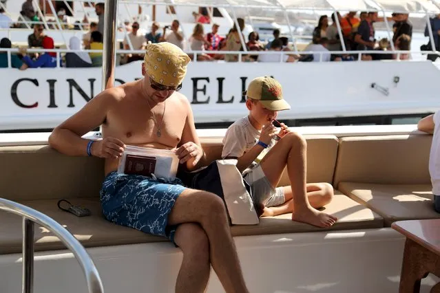 A Russian tourist checks his documents as he sits on a yacht for an excursion at a small port of the Red Sea resort of Sharm el-Sheikh, November 7, 2015. (Photo by Asmaa Waguih/Reuters)