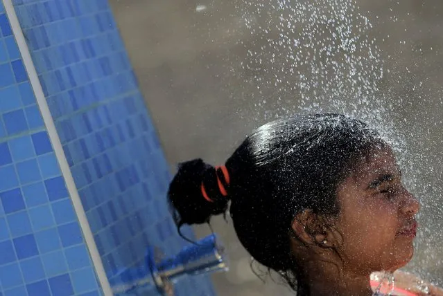A girl uses a public shower near the beach, towards the end of summer vacation for schools, at El Ain El Sokhna in Suez, east of Cairo, Egypt, September 5, 2015. (Photo by Amr Abdallah Dalsh/Reuters)