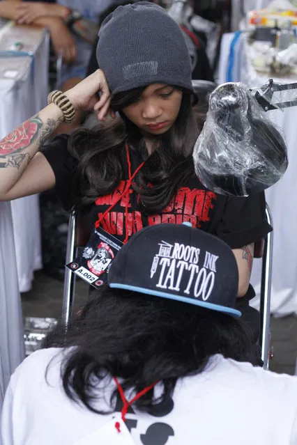 A girl gets a tattoo on her leg during Bandung Body Art Festival at in Bandung, West Java, on December 7, 2014. (Photo by Rezza Estily/JG Photo)