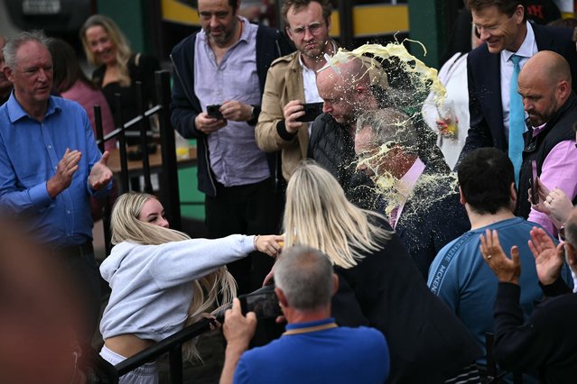 A person throws a drink in the face of newly appointed leader of Britain's right-wing populist party, Reform UK, and the party's parliamentary candidate for Clacton, Nigel Farage, during his general election campaign launch in Clacton-on-Sea, eastern England, on June 4, 2024. Nigel Farage on Monday said he would stand as a candidate for the anti-immigration Reform UK party in Britain's general election next month, after initially ruling out running. “I have changed my mind... I am going to stand”, Farage, 60, told a news conference. He will seek election on July 4 in the fiercely pro-Brexit seat of Clacton, southeast England. (Photo by Ben Stansall/AFP Photo)