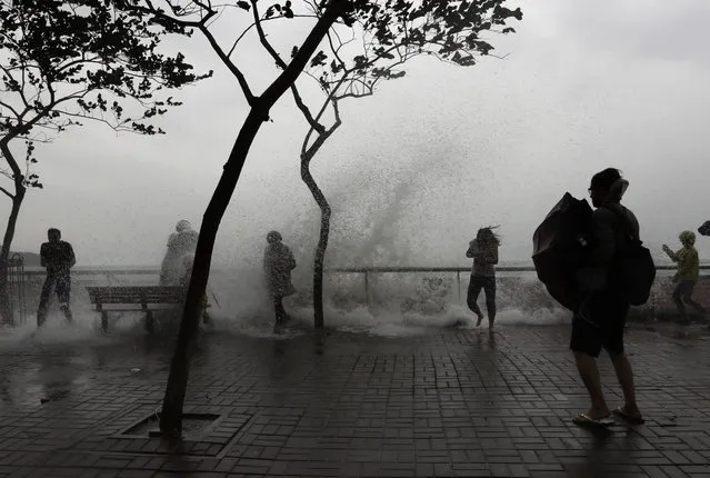 People play with overflown water caused by Typhoon Haima in Hong Kong, Friday, October 21, 2016. (Photo by Kin Cheung/AP Photo)