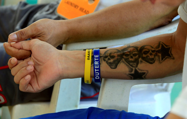 A drug user undergoing rehabilitation wears wrist bands with the name of Philippines' President Rodrigo Duterte while reciting prayers as part of his regular activities at the Center for Christian Recovery in Antipolo, Philippines September 12, 2016. (Photo by Romeo Ranoco/Reuters)