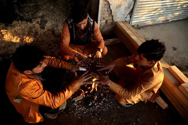 Afghan people gather around a fire to beat the cold in Jalalabad, Afghanistan, 28 December 2020. Due to the shortage of electricity, the majority of people in Afghanistan use coal and wood, as the only energy supply for warming their houses and cooking during the winter season. (Photo by Ghulamullah Habibi/EPA/EFE)