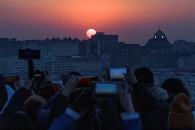 People take pictures the first sunrise of the New Year in Beijing, China, January 1, 2021. (Photo by Thomas Peter/Reuters)