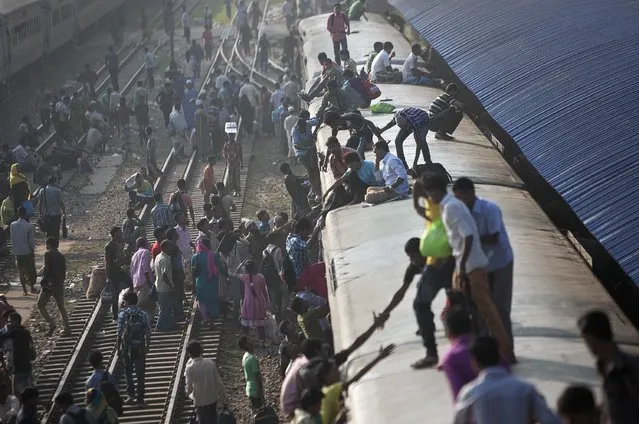Bangladeshi Muslims climb on the roof of an overcrowded train as they head to their homes the day before the Eid-al-Adha Festival October 5, 2014 in Dhaka, Bangladesh. Eid Al-Adha, known as the 'Feast of the Sacrifice', is one of the most significant festivals on the Muslim calendar and lasts for four days. (Photo by Allison Joyce/Getty Images)