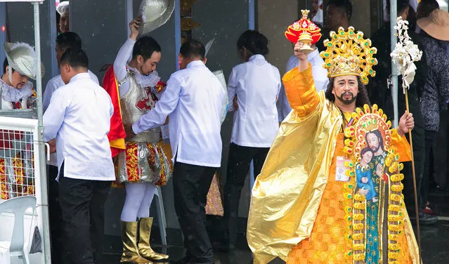 A costumed performer raises an image of the Santo Nino (Holy Child) to the crowd hours before the final papal mass of Pope Francis at Quirino Grandstand in Manila, Philippines, Sunday, January 18, 2015. Millions filled Manila's main park and surrounding areas for Pope Francis' final Mass in the Philippines on Sunday. (Photo by Ron Soliman/AP Photo)
