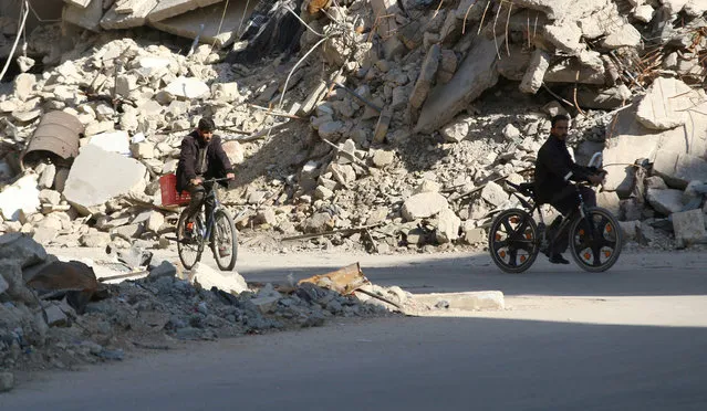 Men ride bicycles near rubble of damaged buildings in a rebel-held besieged area in Aleppo, Syria November 6, 2016. (Photo by Abdalrhman Ismail/Reuters)
