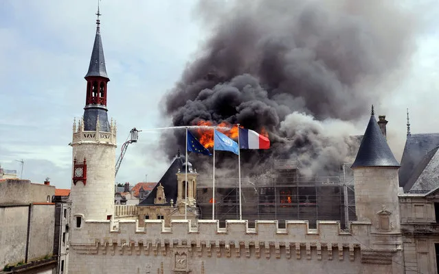 Firemen are at work to extinguish a fire that broke out in La Rochelle city hall, on June 28, 2013 in La Rochelle, western France. The fire swept through the roof of the town hall destroying a part of the listed 15th-Century building. (Photo by Xavier Leoty/AFP Photo)