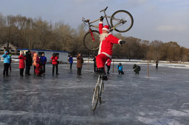 A man dressed as Santa Claus performs stunt with bicycles on ice, in Changchun, Jilin province, China December 15, 2015. (Photo by Reuters/China Daily)